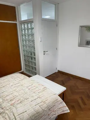 a bedroom with a large bed and a door at Departamento Centro Córdoba con Cochera Privada in Cordoba