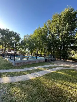 a park with a fence and trees and grass at Cabañas Torres in Mina Clavero