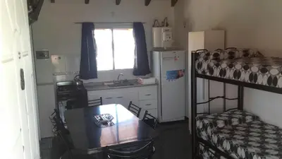 a small kitchen with a table and a bunk bed at Complejo sierras de brochero in La Porteña