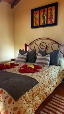 a bedroom with a large bed with a patterned blanket at Complejo sierras de brochero in La Porteña