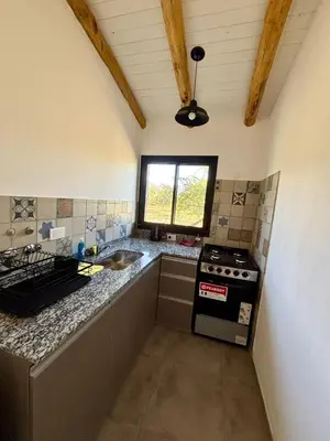 a kitchen with a stove and a sink in it at La Corrida hospedaje in San Javier