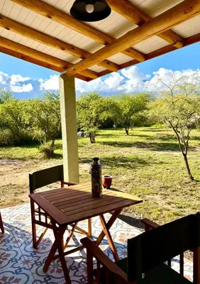 a picnic table on a porch with a view of a field at La Corrida hospedaje in San Javier