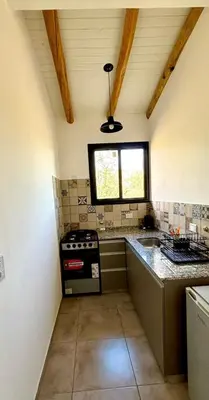 a small kitchen with a stove and a window at La Corrida hospedaje in San Javier