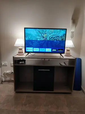 a flat screen tv sitting on a desk with two lamps at Departamento en Carlos Paz, céntrico in Villa Carlos Paz