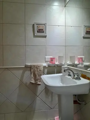 a white bathroom with a sink and a mirror at Departamento en Carlos Paz, céntrico in Villa Carlos Paz