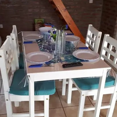a white table with chairs and plates and glasses on it at Cabañas Jazmines del Lago in San Roque