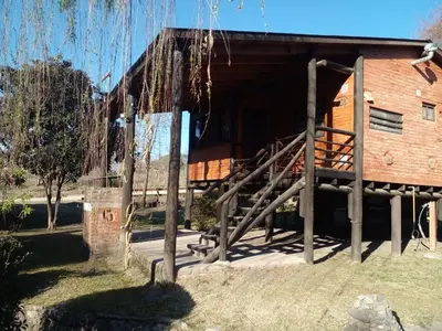 a building with a wooden staircase in front of it at Complejo Don Emilio in Los Reartes