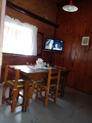 a dining room with a table and chairs and a television at Complejo Don Emilio in Los Reartes