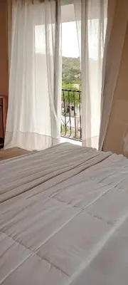 a bedroom with a white bed with a window at Chañares Complejo de Montaña - Solo Familias y Parejas in Villa Carlos Paz