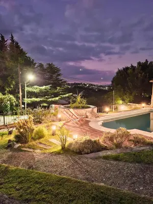 a garden with a swimming pool at night at Chañares Complejo de Montaña - Solo Familias y Parejas in Villa Carlos Paz