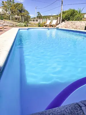 a swimming pool filled with blue water at Chañares Complejo de Montaña - Solo Familias y Parejas in Villa Carlos Paz