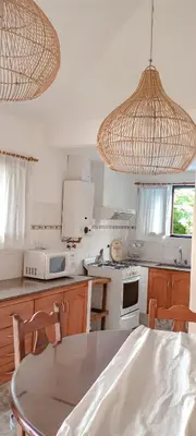a kitchen with a table and chairs in it at Chañares Complejo de Montaña - Solo Familias y Parejas in Villa Carlos Paz