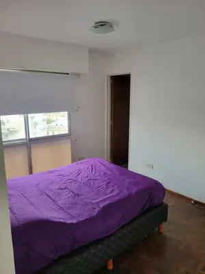 a purple bed in a room with a window at departamento centro zona tribunales cordoba in Cordoba