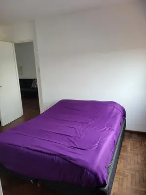 a purple bed in a room with a wall at departamento centro zona tribunales cordoba in Cordoba