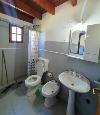 a bathroom with a toilet and a sink at Cabañas Pioneras in Villa Rumipal