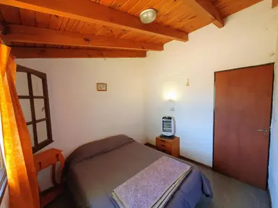 a bedroom with a bed and a wooden ceiling at Cabañas Pioneras in Villa Rumipal