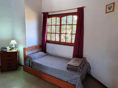 a bedroom with a bed and a window at Cabañas Pioneras in Villa Rumipal