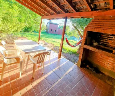 a patio with a table and chairs and a fireplace at Cabañas Pioneras in Villa Rumipal