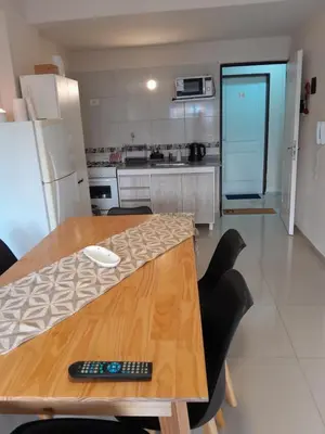 a kitchen with a wooden table with a remote control on it at Departamento Anita Villa Carlos Paz in Villa Carlos Paz