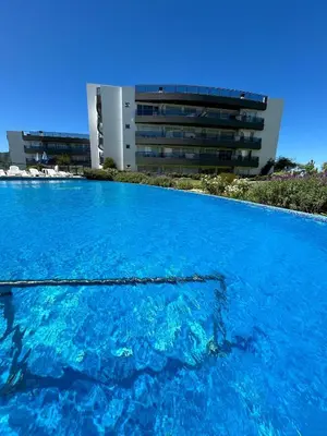 a large pool of blue water in front of a building at Veneto Village in Villa Parque Siquiman