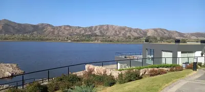 a house next to a lake with mountains in the background at Veneto Village in Villa Parque Siquiman