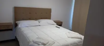 a bed with white sheets and pillows in a room at Veneto Village in Villa Parque Siquiman