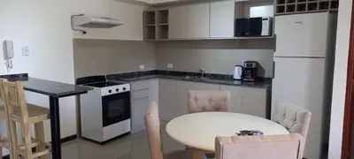 a kitchen with a table and a white refrigerator at Veneto Village in Villa Parque Siquiman