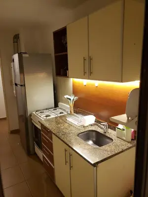 a kitchen with a sink and a refrigerator at Departamento céntrico con hermosa vista a las Sierras in Cordoba