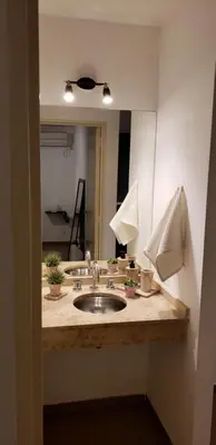 a bathroom counter with a sink and a mirror at Departamento céntrico con hermosa vista a las Sierras in Cordoba