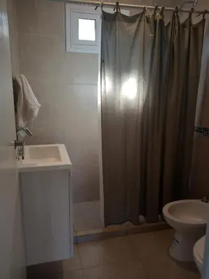 a bathroom with a shower curtain and a sink at EL Mirador Soñado in Villa Carlos Paz