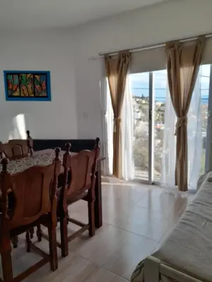 a bedroom with a table and chairs and a window at EL Mirador Soñado in Villa Carlos Paz