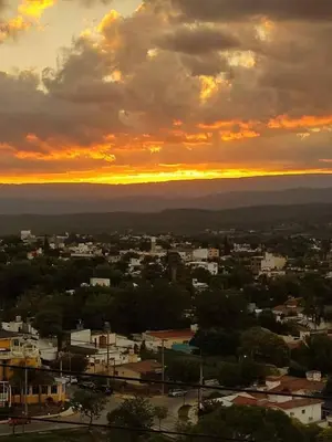 a view of a city with a sunset in the background at EL Mirador Soñado in Villa Carlos Paz