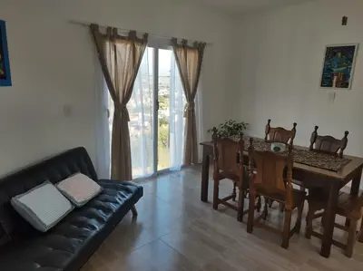 a living room with a couch and a dining room table at EL Mirador Soñado in Villa Carlos Paz