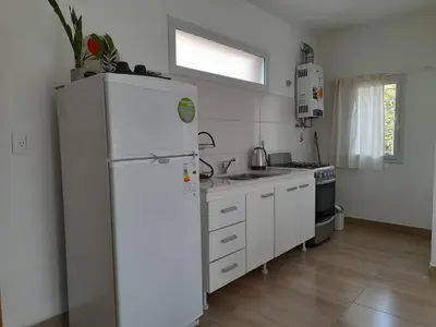 a white kitchen with a refrigerator and a sink at EL Mirador Soñado in Villa Carlos Paz