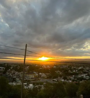 a view of a city with the sun setting at EL Mirador Soñado in Villa Carlos Paz