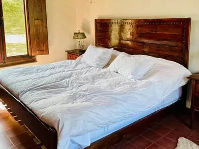 a large bed with a wooden headboard in a bedroom at Cabañas San Javier in Pueblito