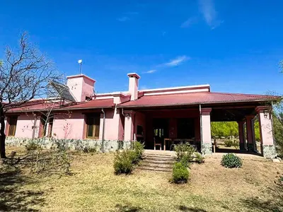 a large pink house with a red roof at Cabañas San Javier in Pueblito
