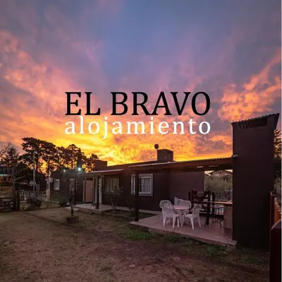 a house with a sunset in the background at El Bravo Alojamiento in Villa Rumipal