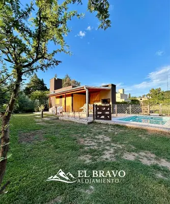 a house with a pool in front of a yard at El Bravo Alojamiento in Villa Rumipal
