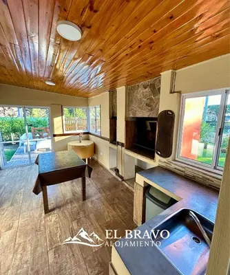 a living room with a wooden ceiling and a table at El Bravo Alojamiento in Villa Rumipal