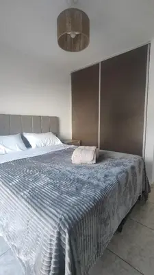 a bedroom with a large bed with a blue blanket at Anicca Alberdi Córdoba Centro in Cordoba
