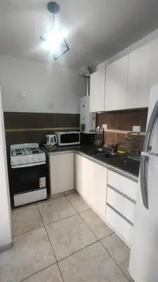 a kitchen with white cabinets and a stove top oven at Anicca Alberdi Córdoba Centro in Cordoba