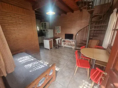 a room with a table and a kitchen and a staircase at Duplex Las Violetas in Merlo