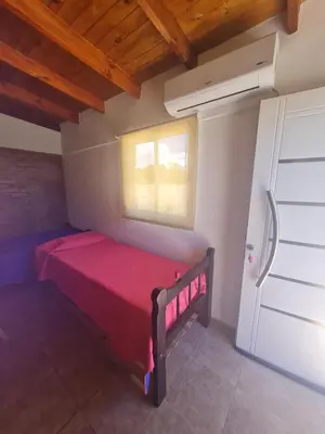 a small bedroom with a red bed and a window at Dálet in Villa Parque Siquiman