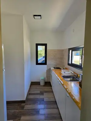 a kitchen with white cabinets and a wooden counter top at Gaviotas del Sur in Potrero de Garay