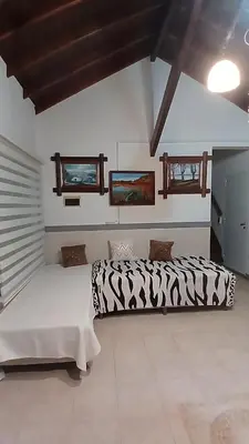 a bedroom with two beds and two monitors on the wall at CASA TODA EN PLANTA BAJA CON PARQUE y PILETA INDIVIDUAL SOBRE ASFALTO A POCAS CUADRAS DEL CENTRO DE MERLO in Merlo