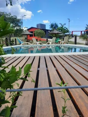a wooden bench next to a swimming pool at Cabañas Tanti in Tanti