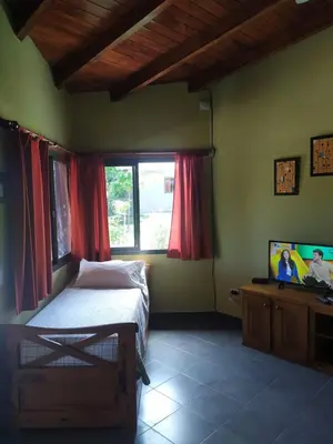 a bedroom with a bed and a flat screen tv at Cabañas Tanti in Tanti