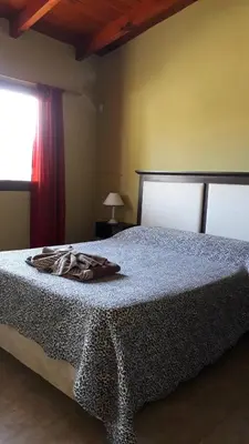 a bedroom with a bed with a robe on it at Cabañas Tanti in Tanti