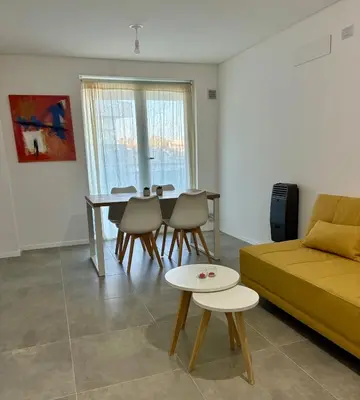 a living room with a couch and a table and chairs at Departamento Complejo Ciudad Gama in Cordoba